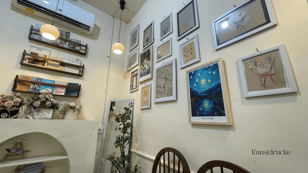 Warum minimalistische Kunstdrucke Räume ruhiger wirken lassen – elegante Galerieanordnung in einem Café.